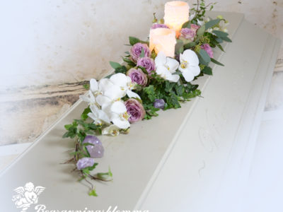 kistdekoration med lila rosor